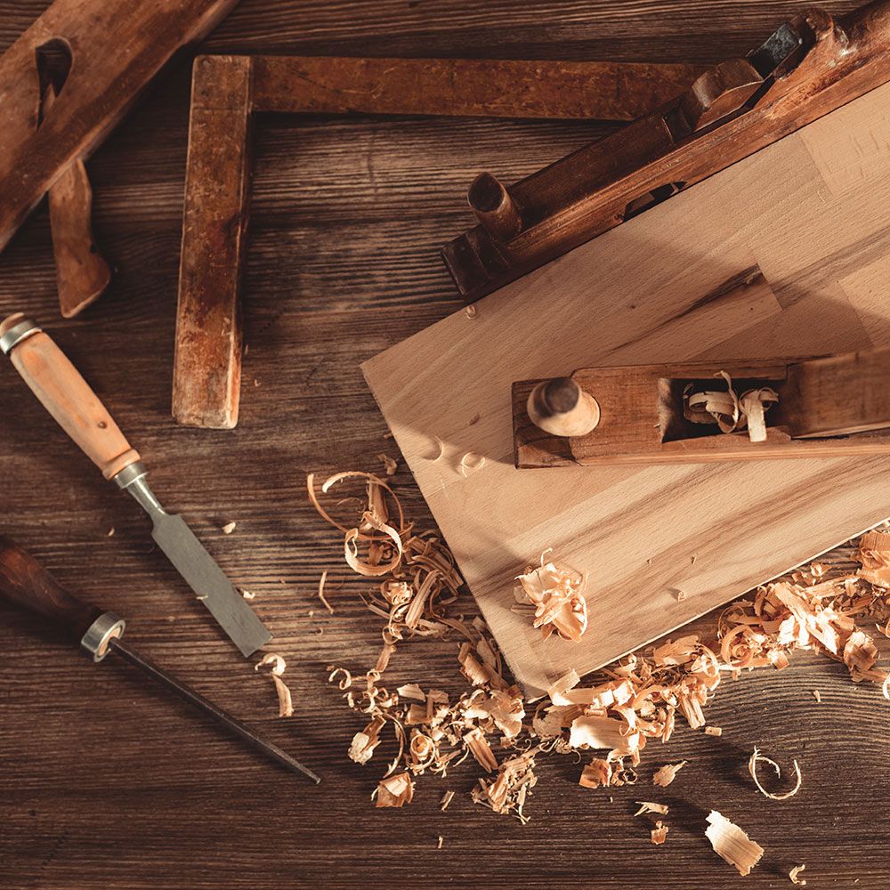 Tischlerwerkzeug von Spänen umgeben liegt auf einem Tisch